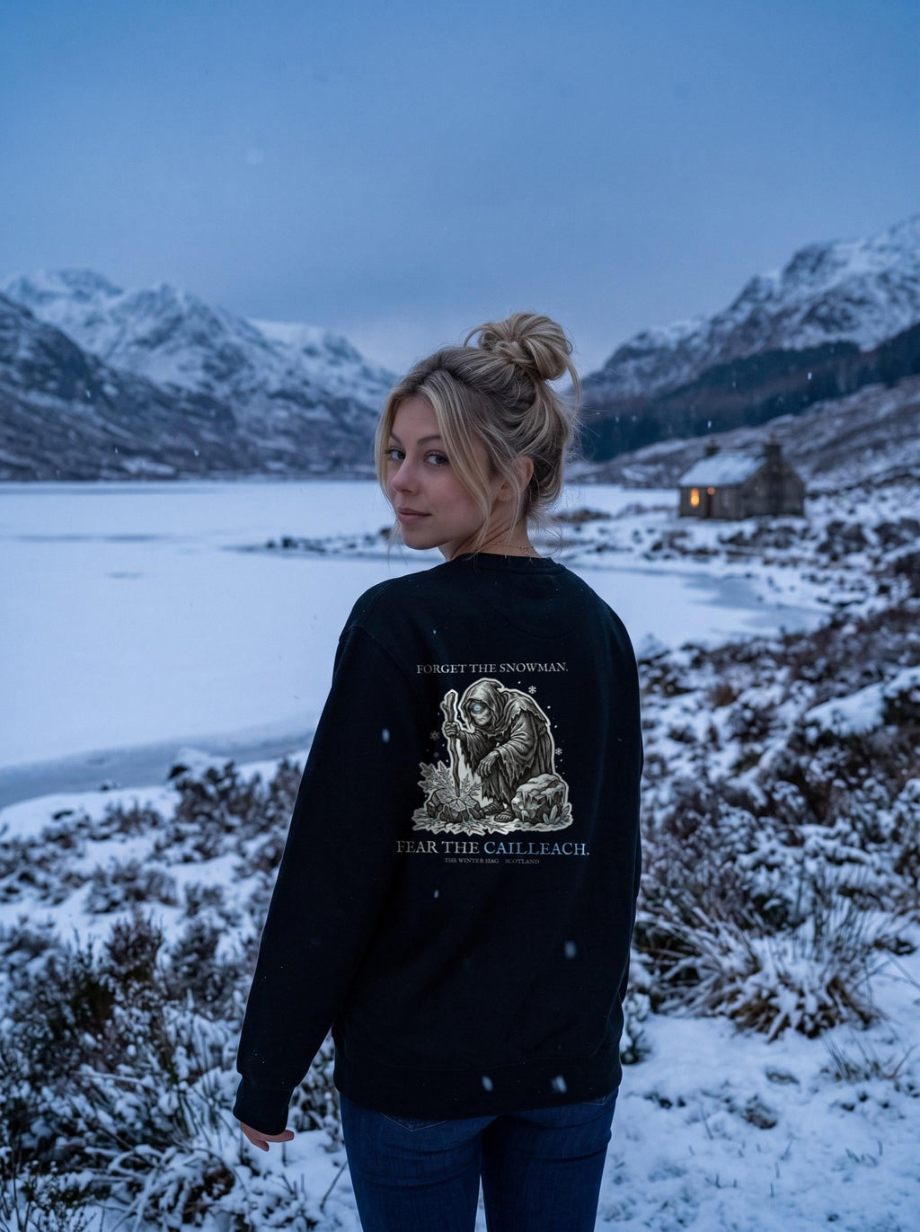 Cailleach Christmas jumper (crewneck sweatshirt) worn in a winter scene, showing the big back print